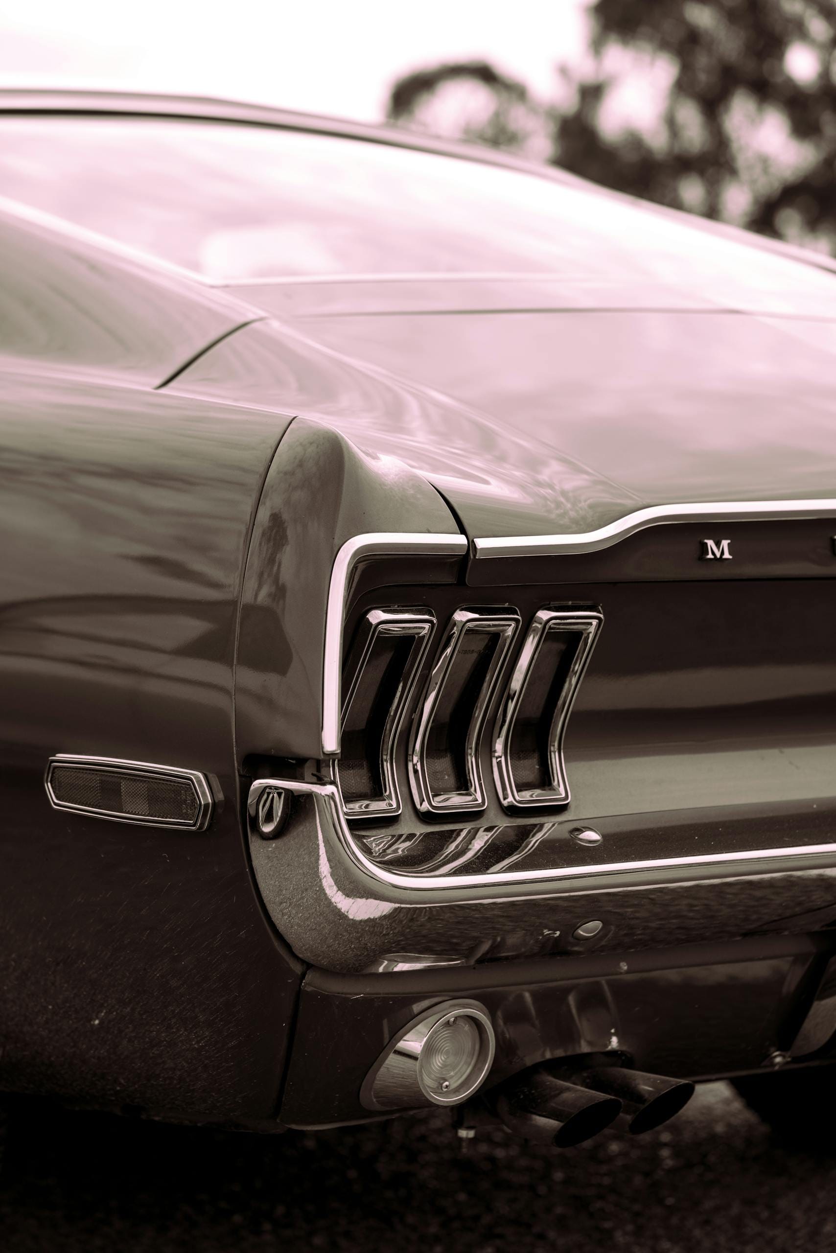 Close-up shot of a sleek vintage Ford Mustang with chrome detailing.